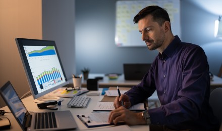 man at desk looking over KPIs