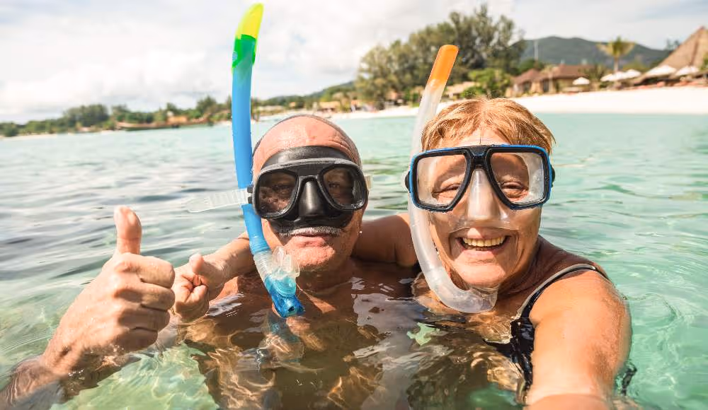 happy retired couple taking selfie in tropical sea