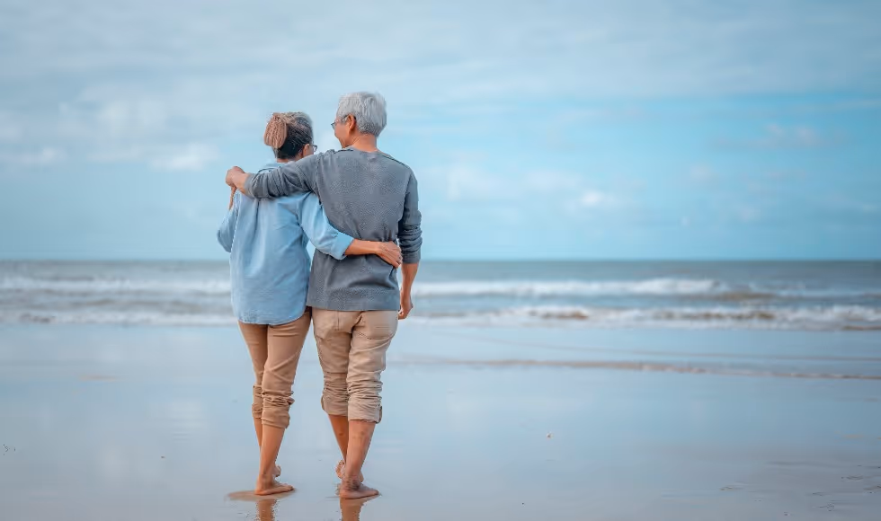 older couple walking down the beach