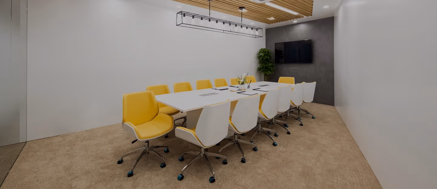 Large modern conference room with yellow chairs around a long table