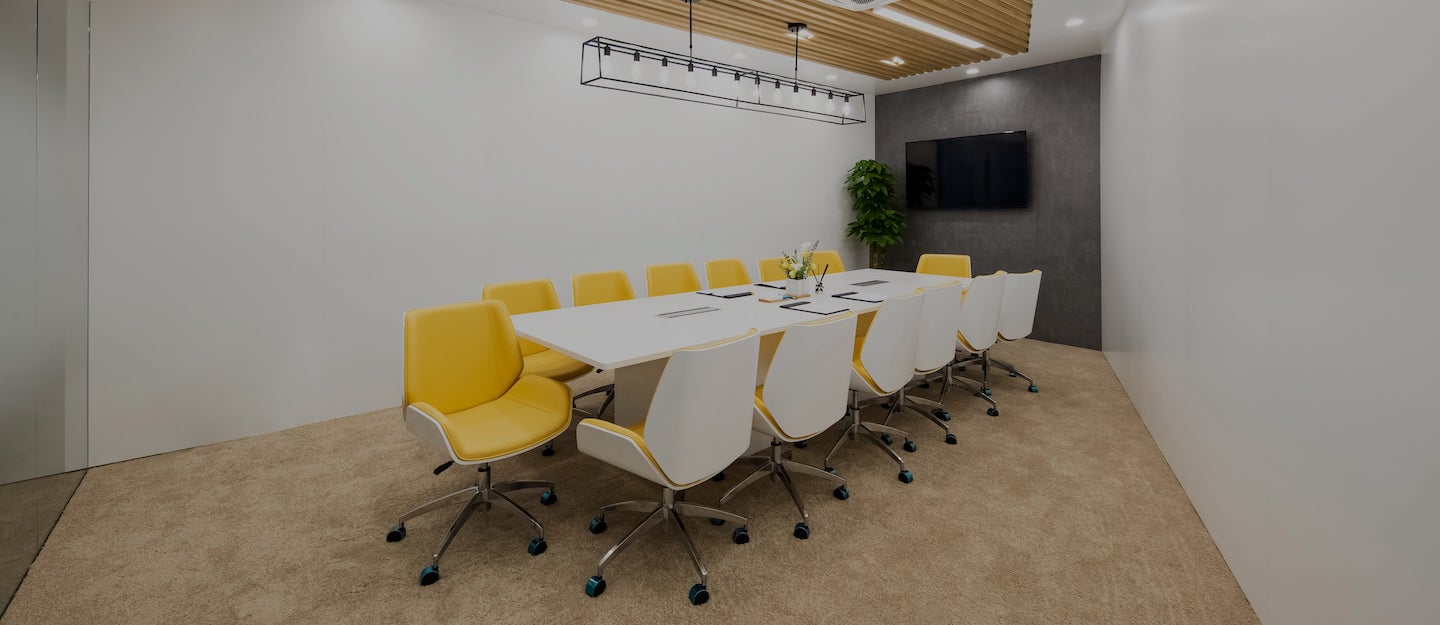 Large modern conference room with yellow chairs around a long table