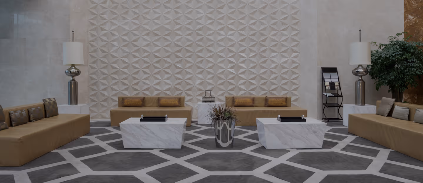 Modern lobby atrium with four beige sofas and two marble coffee tables