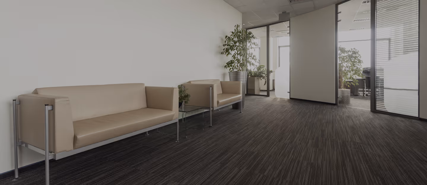 Empty hallway with two beige sofas outside of offices