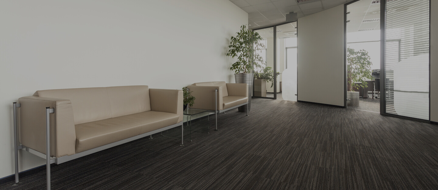 Empty hallway with two beige sofas outside of offices