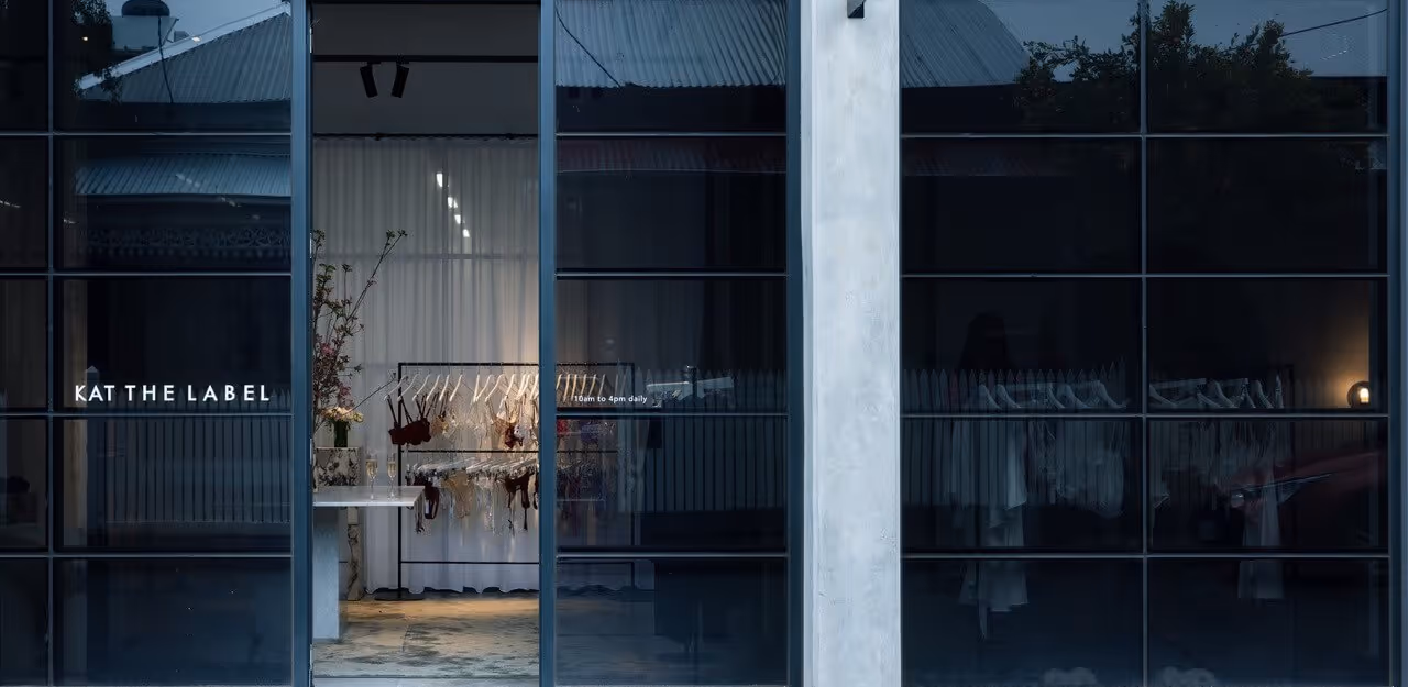 A shopper pausing to look at garments and accessories displayed in a boutique window.