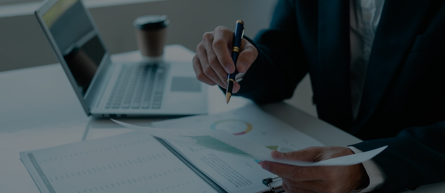 A planner tracing a projection curve on a chart while a client watches across the table.