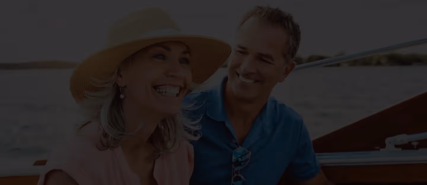 Two mature adults standing outside in relaxed clothing and talking face-to-face.
