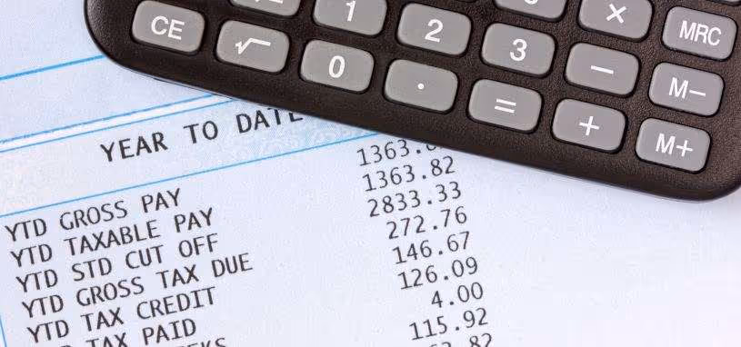 payroll taxA closeup of the summary figures on a business’s tax statement. A calculator is at the edge of the image, suggesting someone’s working through their corporate taxes.