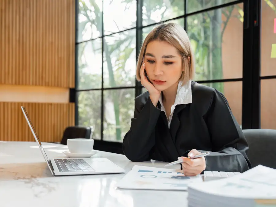 A young female professional shows worry about her finances.