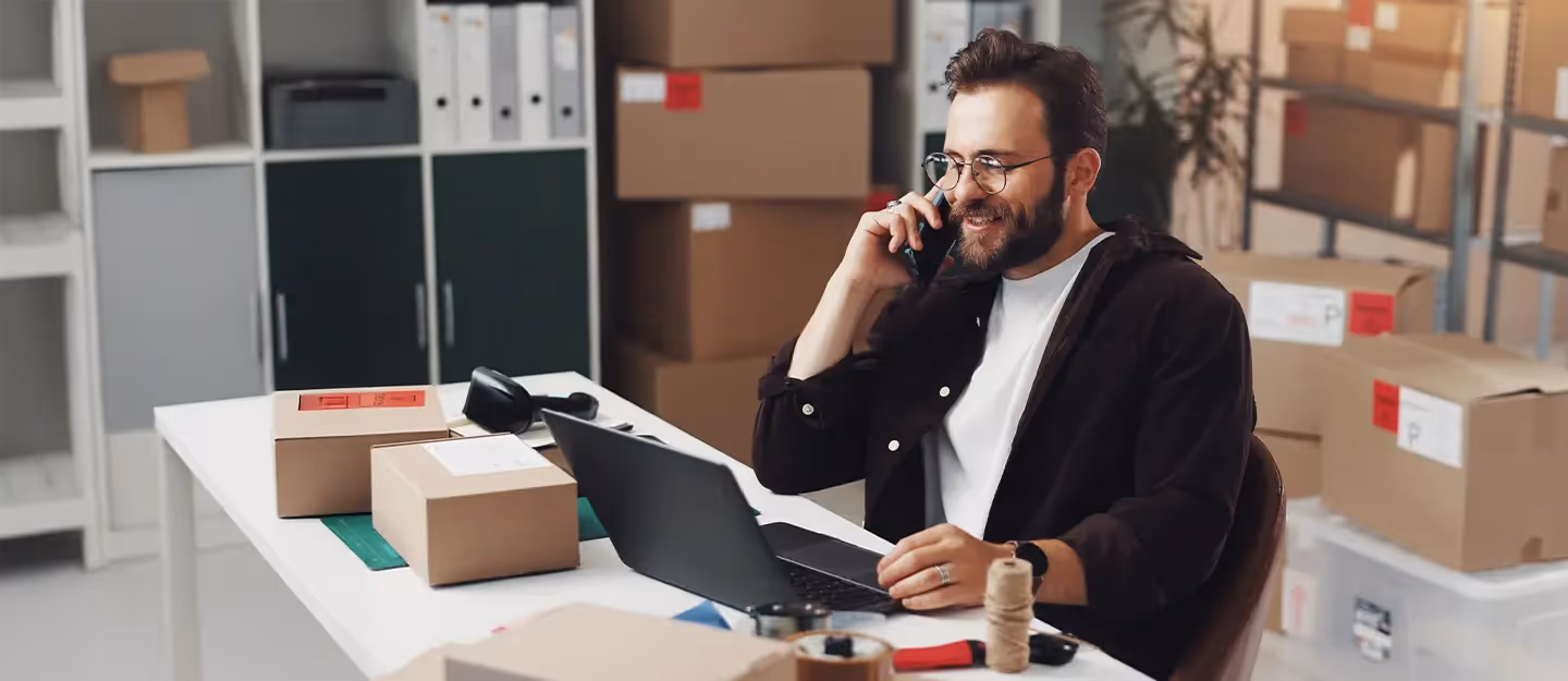 Wholesale business owner managing orders, invoices, and customer accounts from a warehouse office.
