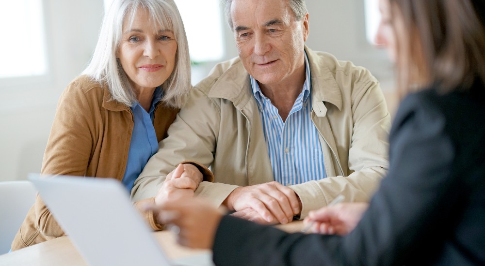 Older couple discussing aged care planning and financial options with an adviser to prepare for their future care needs.