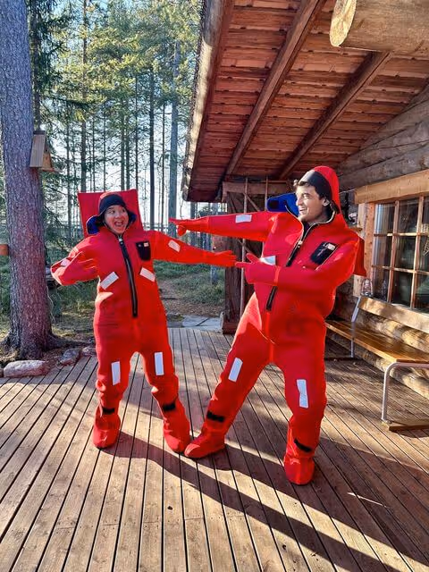 Peaceful scene of individuals in warm, dry suits floating effortlessly on a serene lake during an autumn tour.