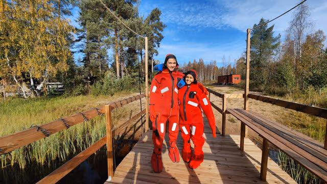 A person in a specialized thermal floating suit enjoying the calm waters of an autumn lake in Rovaniemi, Lapland.
