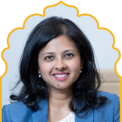 Smiling woman with black hair wearing a blue blazer and white top, framed by a yellow ornamental outline.