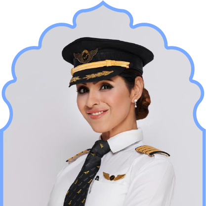 Smiling female airline pilot in uniform with cap, white shirt, and black tie.