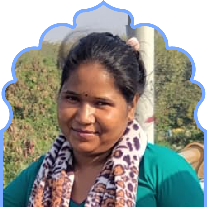 Woman with dark hair tied back, wearing a teal top and a leopard print scarf, smiling outdoors with greenery in the background.