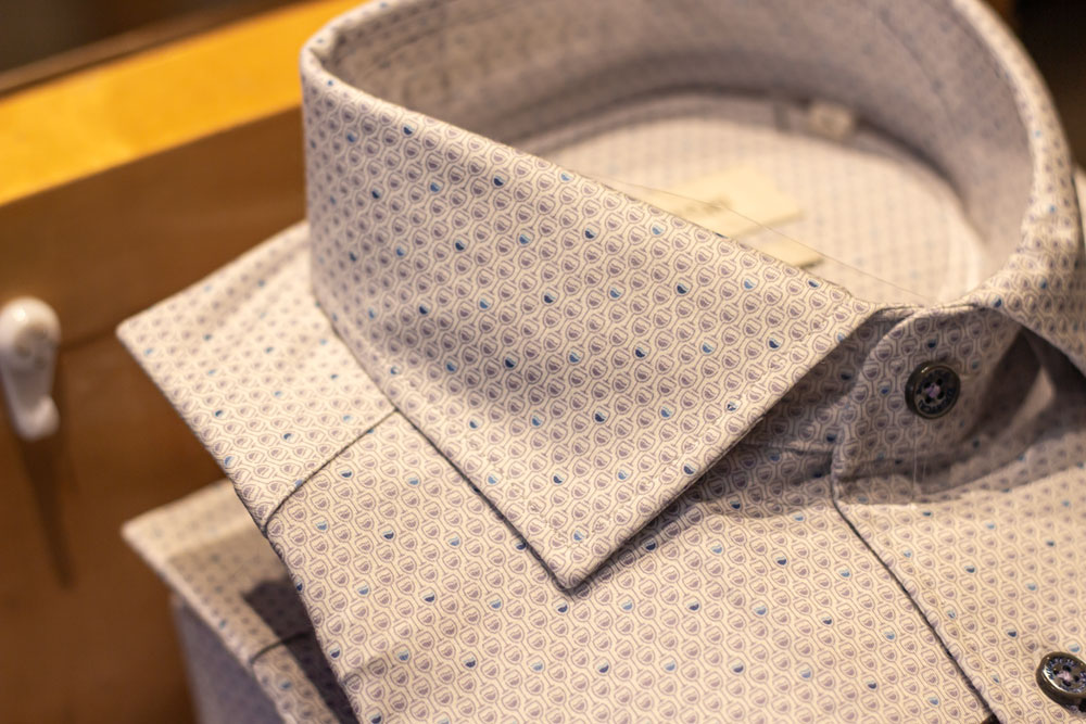 White leather sneakers paired with folded floral print shirts