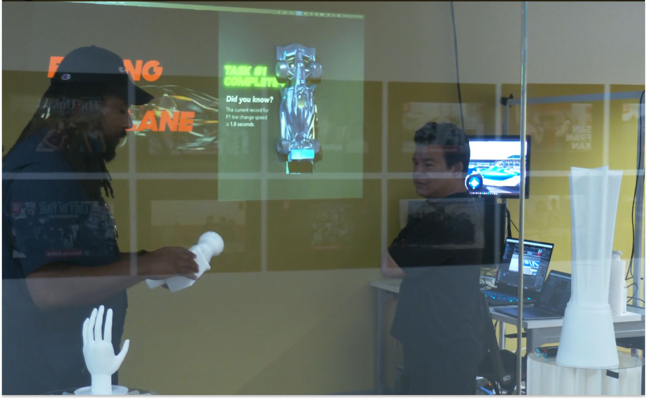 Showing complimentary 3D printed pieces explaining my thesis to a booth visitor, with a projection mapped experience for users not in-headset playing in the background