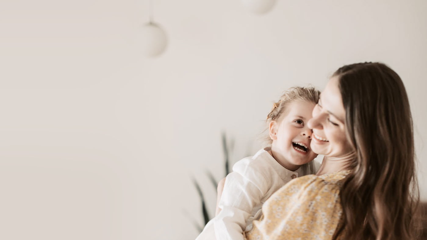 Moeder met kind op haar arm in een woonkamer