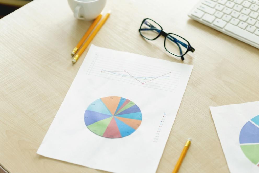 A close-up of a desk with a graph and glassesAI-generated content may be incorrect.