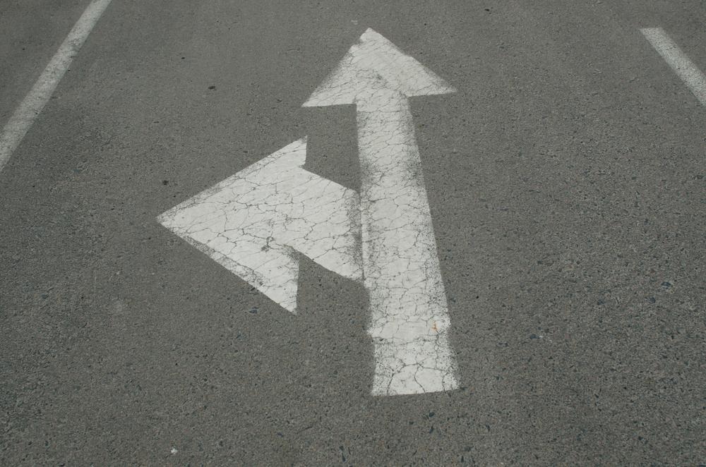 A white arrow painted on the roadAI-generated content may be incorrect.