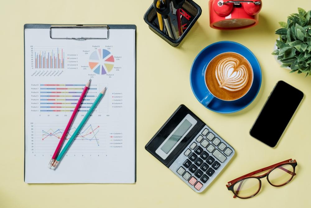 A calculator and coffee on a tableAI-generated content may be incorrect.