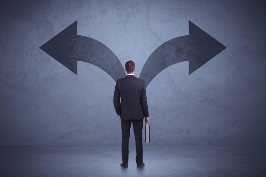 A person standing in front of two arrows pointing at the same directionAI-generated content may be incorrect.