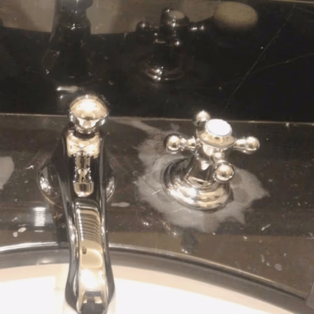 Photo d'un évier en marbre noir pale et taché après d'être rénovée par marble technics paris