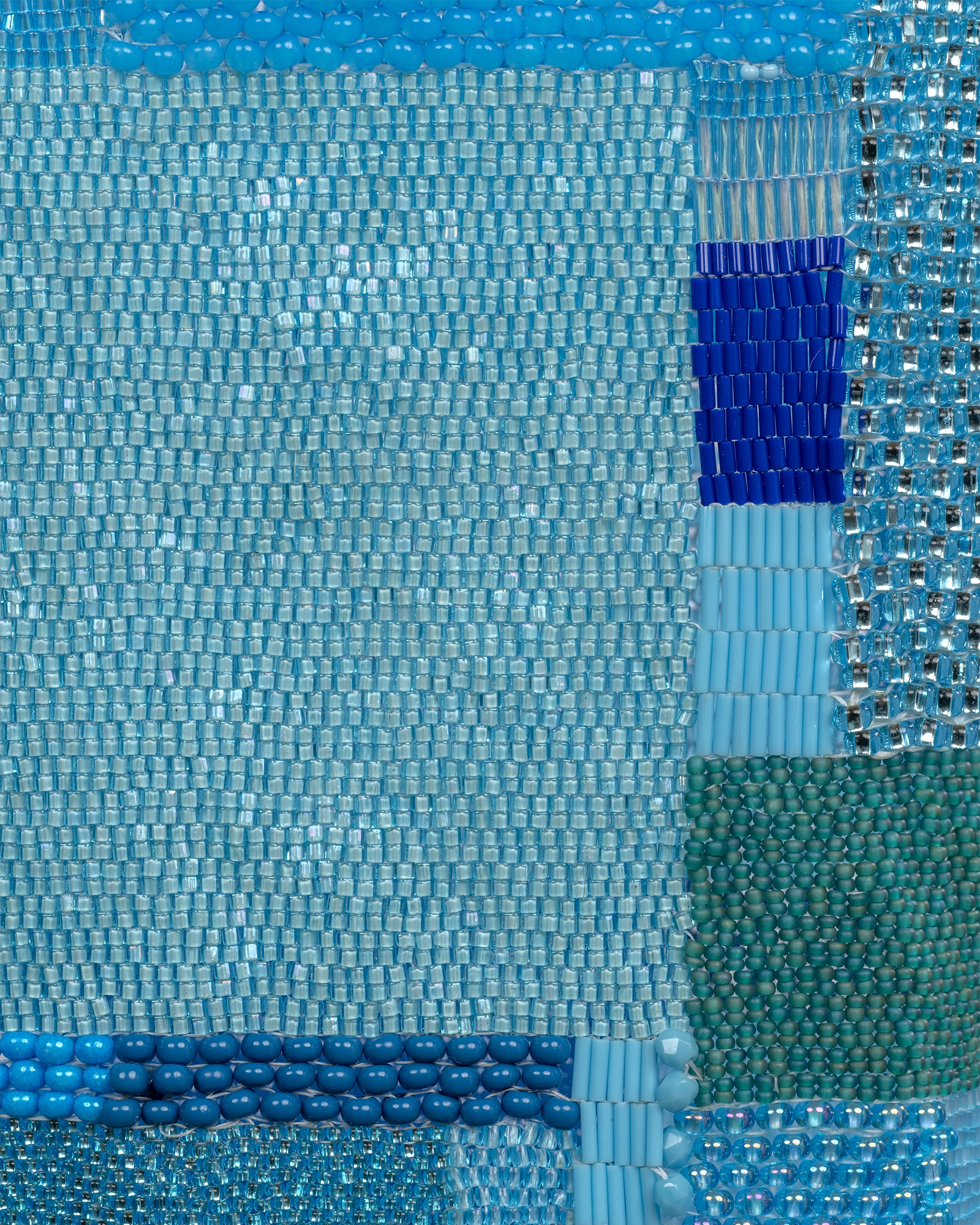 Close-up view of a patchwork hospital gown composed of small rectangular beaded swatches in varied shades of turquoise and blue, by artist Maggie Thompson.