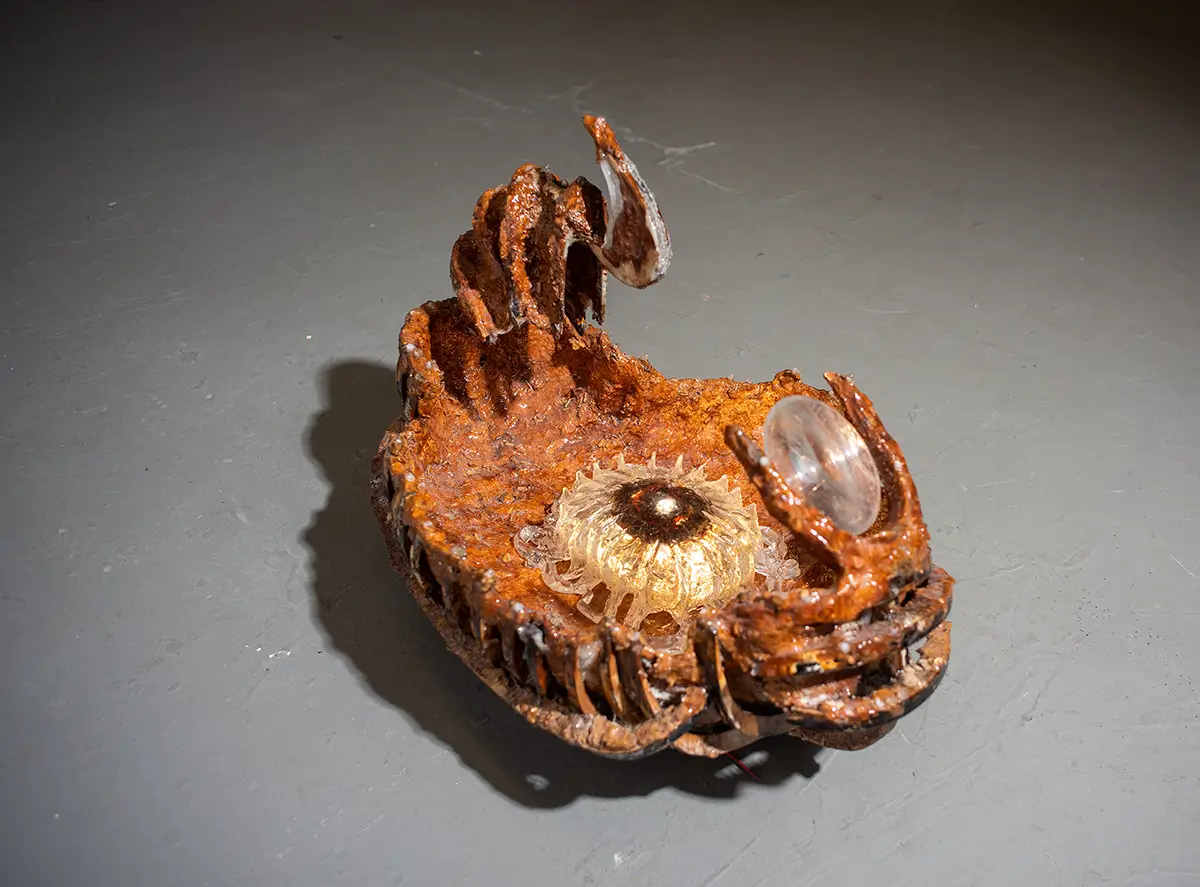 Sasha Fishman, "Can’t Feel My Fingers," 2023, reishi mycelium, firewood, rye, wood, mold, epoxy resin, Fresnel lens, Priscilla (cryo), LED, 16 × 22 × 16 in. Courtesy of the artist.