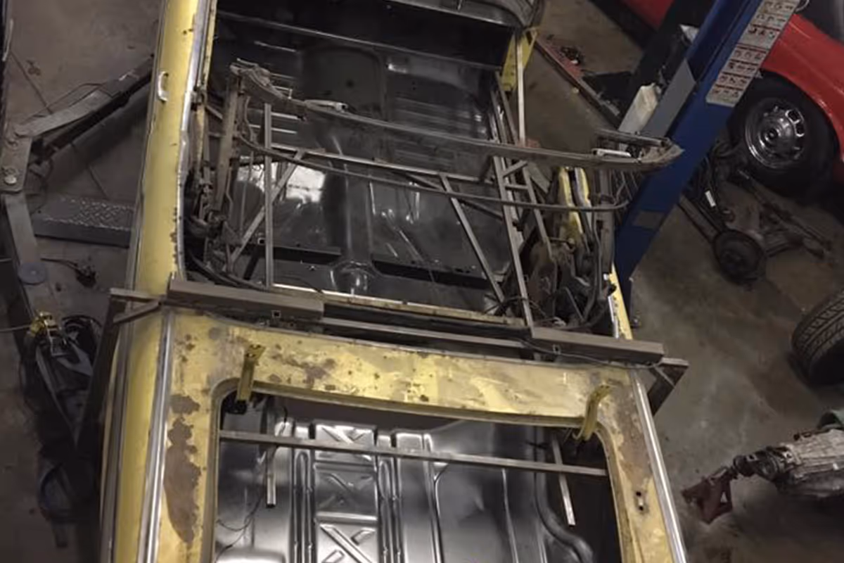 A car with its roof removed, revealing the interior and metal framework.