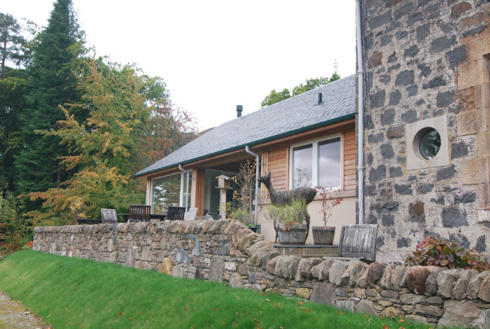 A new extension which takes advantage of the beautiful light and southerly view over the loch, and provides easy access to a partially roofed terrace.