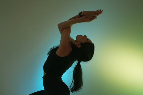 Yoga teacher doing yoga in front of ambient lights