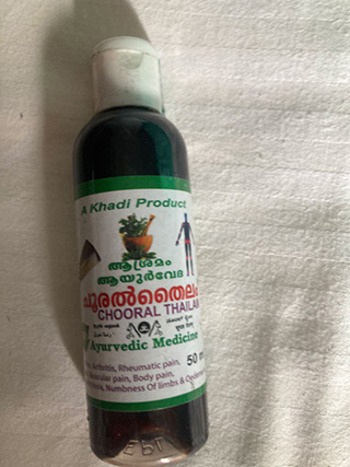 Bottle of Ayurvedic medicine labeled 'Chooral Thailam' for arthritis, rheumatic pain, and body pain.
