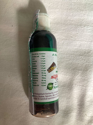 Small dark green bottle with a white label listing herbal ingredients and a white cap.