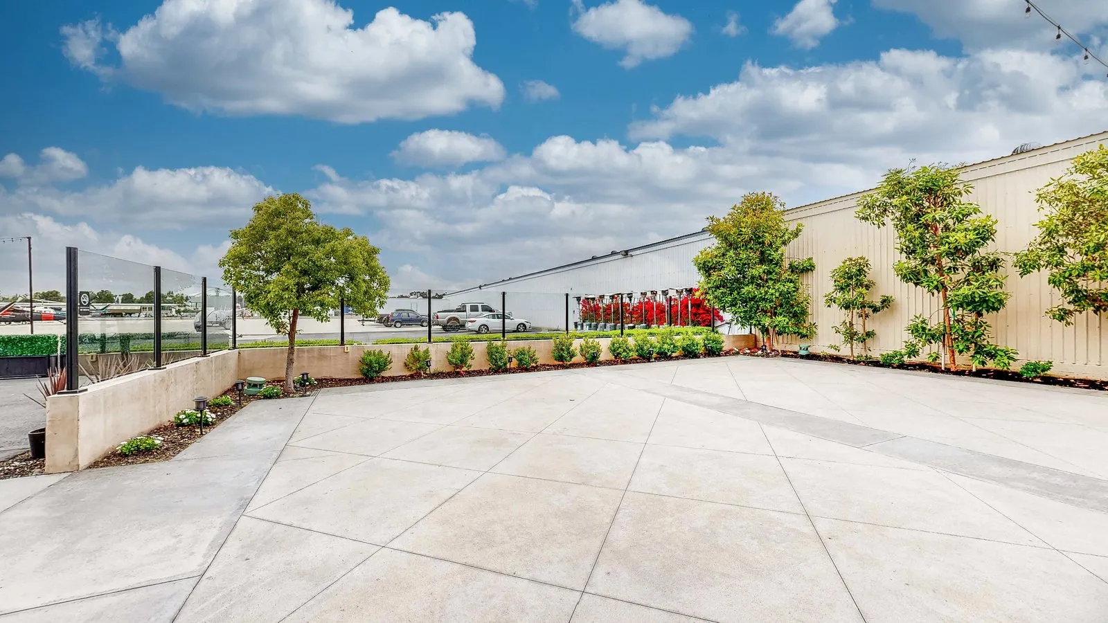 Landscaped outdoor terrace beside the hangar and airport tarmac at Hangar 21