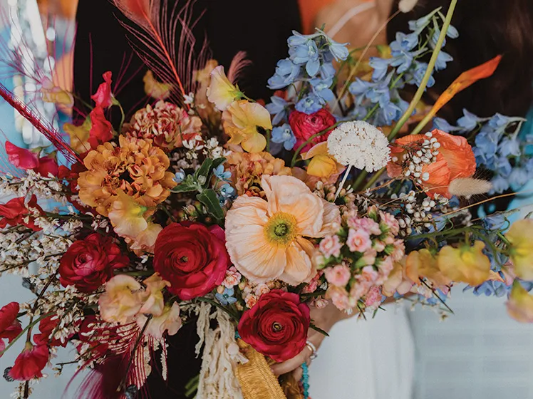 Colorful wedding bouquet with roses and blue flowers