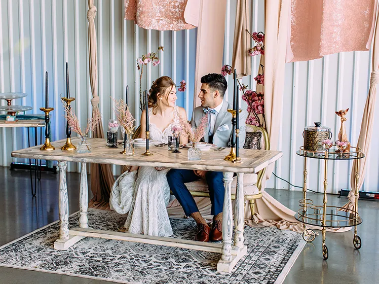 Wedding couple seated at a decorated sweetheart table