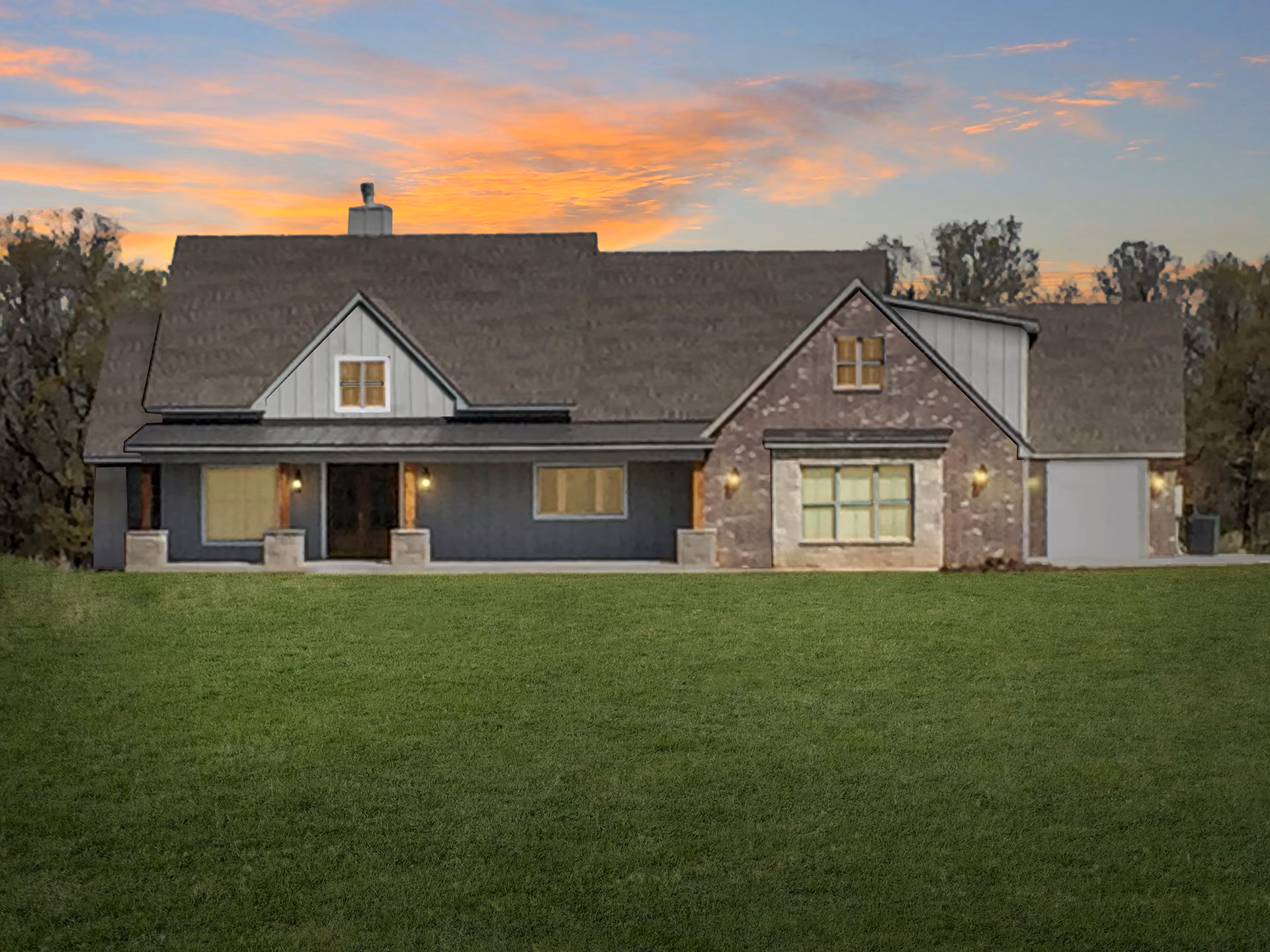 Single-story house with stone and siding exterior, large front lawn, and a sunset sky in the background.
