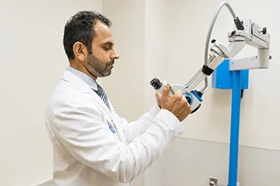 A man in a lab coat using a machine.