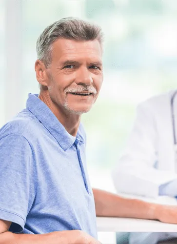 A man in a blue shirt sitting at a table.