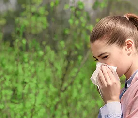 A woman is blowing her nose with a napkin.