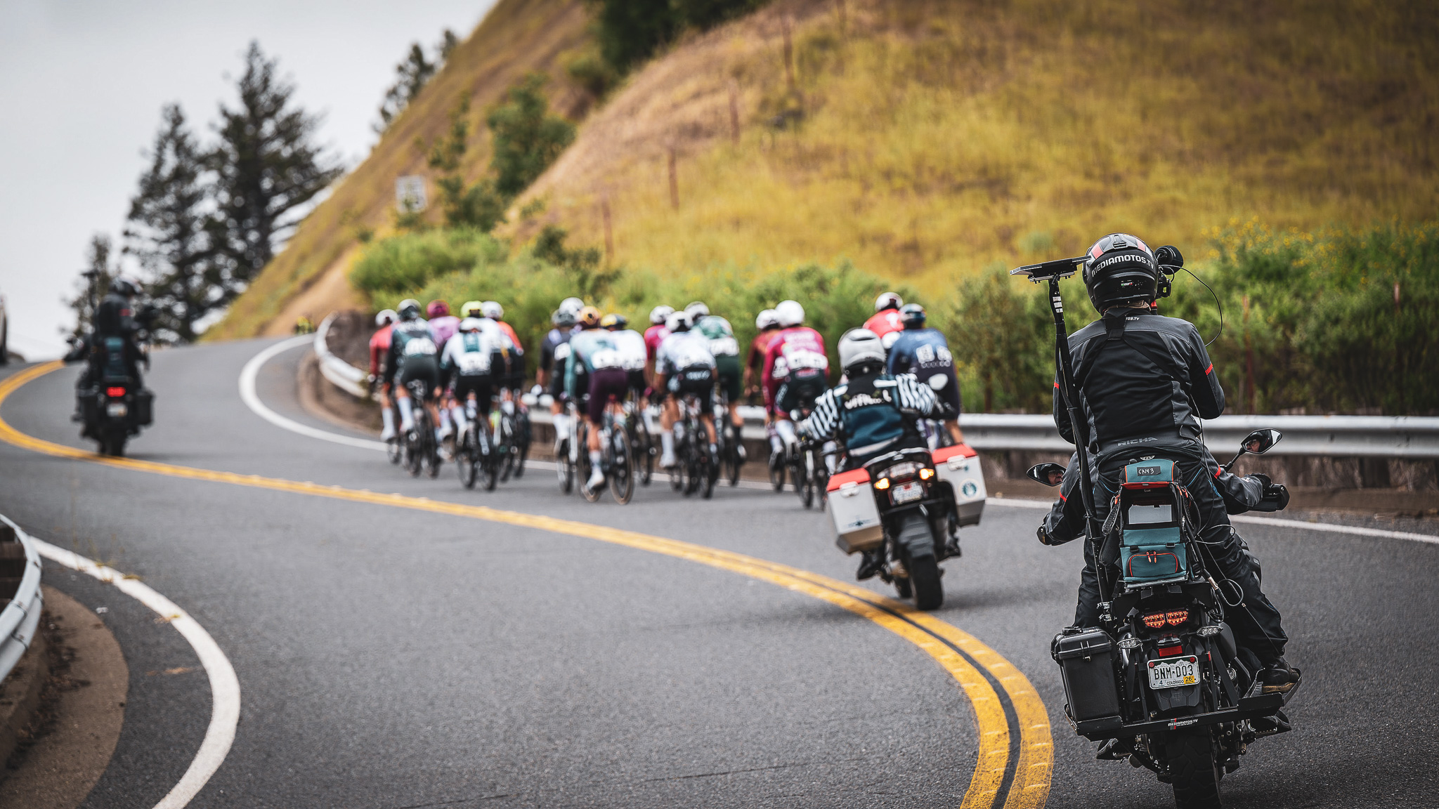 Live broadcast — peloton with media motorcycle on Sonoma roads