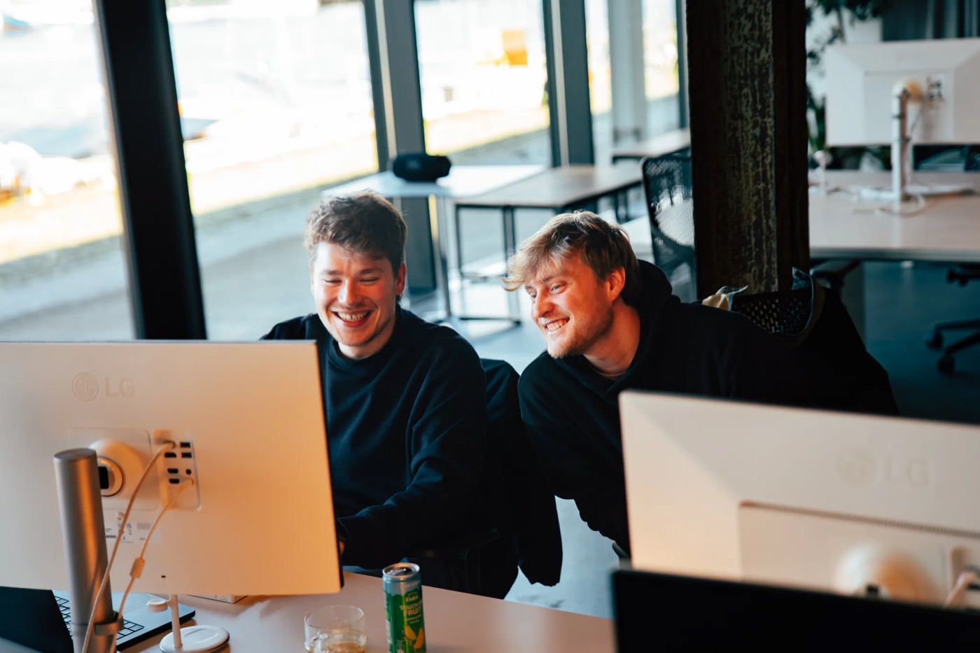 Two Nimble colleagues laughing in front of a screen