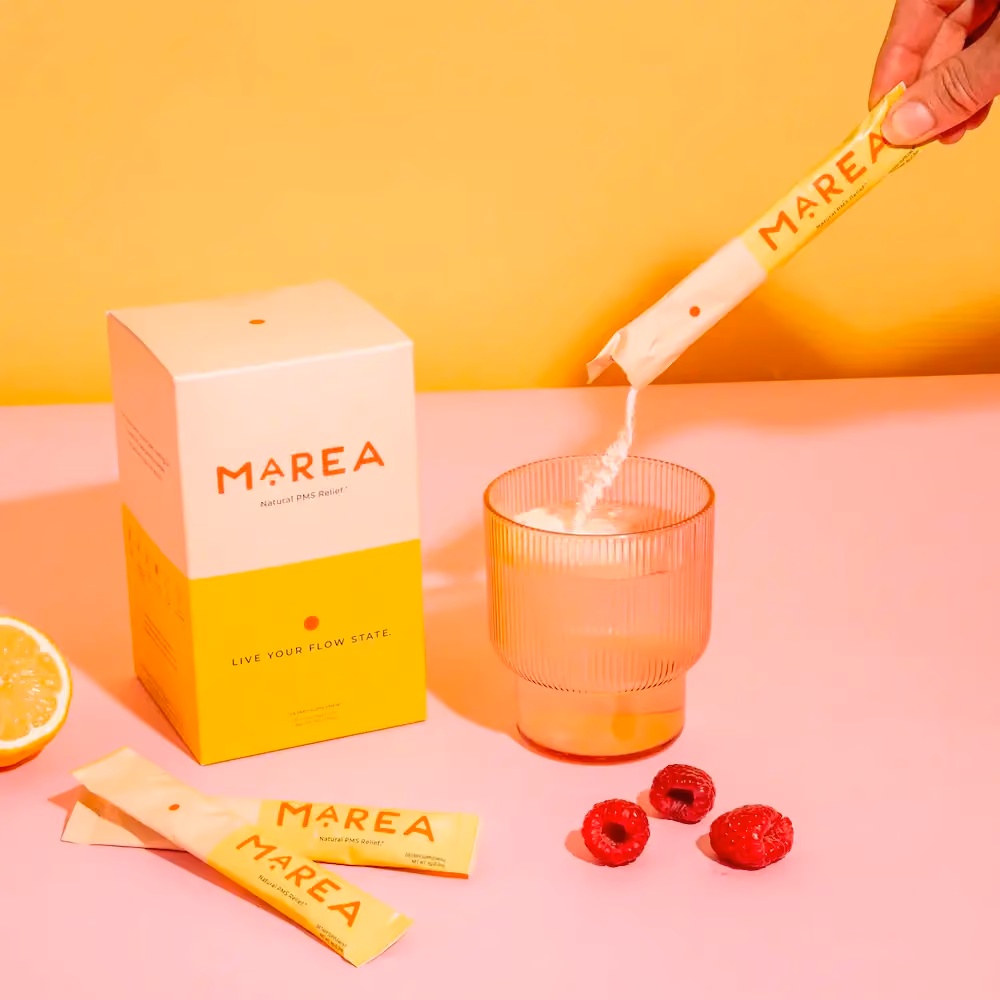 A single-serve packet of Marea's PMS Elixir being poured into a cup of water