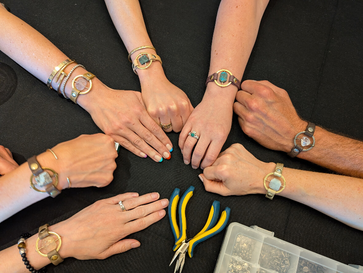 Hands of several people stacked together in a group gesture to symbolize teamwork.