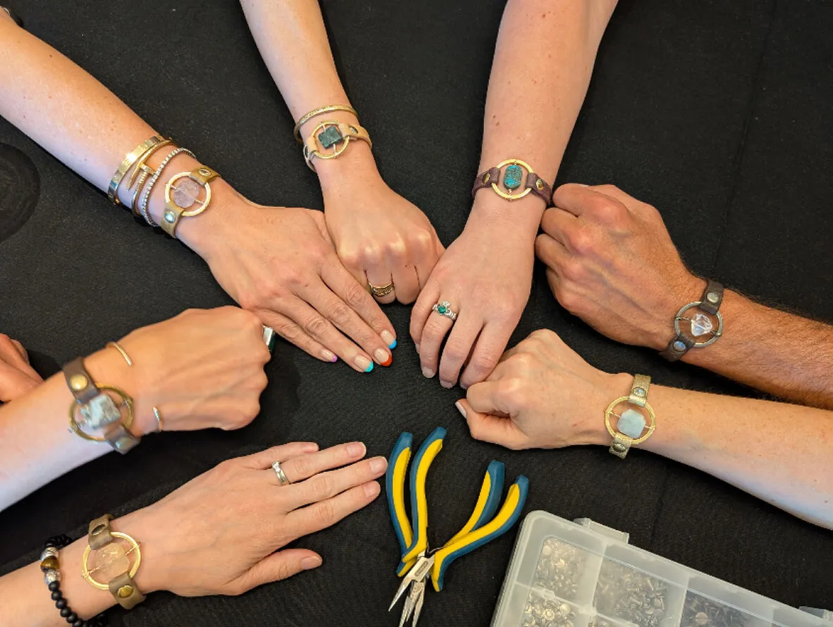 Hands of several people stacked together in a group gesture to symbolize teamwork.