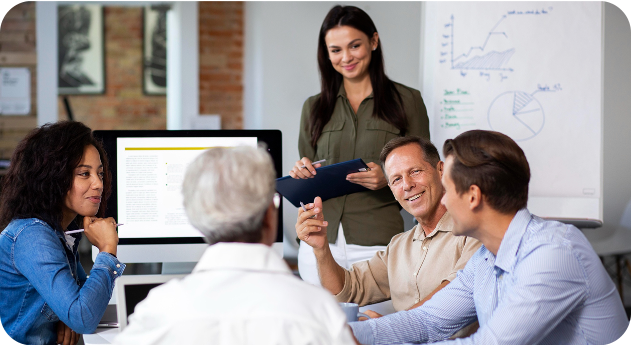 Eine Gruppe von Menschen in einem Büro bei einer Präsentation mit Flipchart im Hintergrund