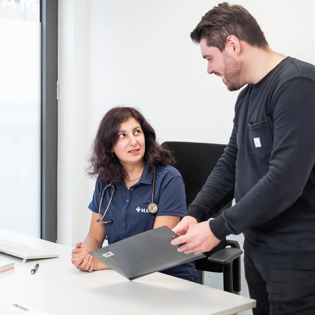 Ärztin und Mitarbeiter im Gespräch – MAS Gesundheitszentrum Essen