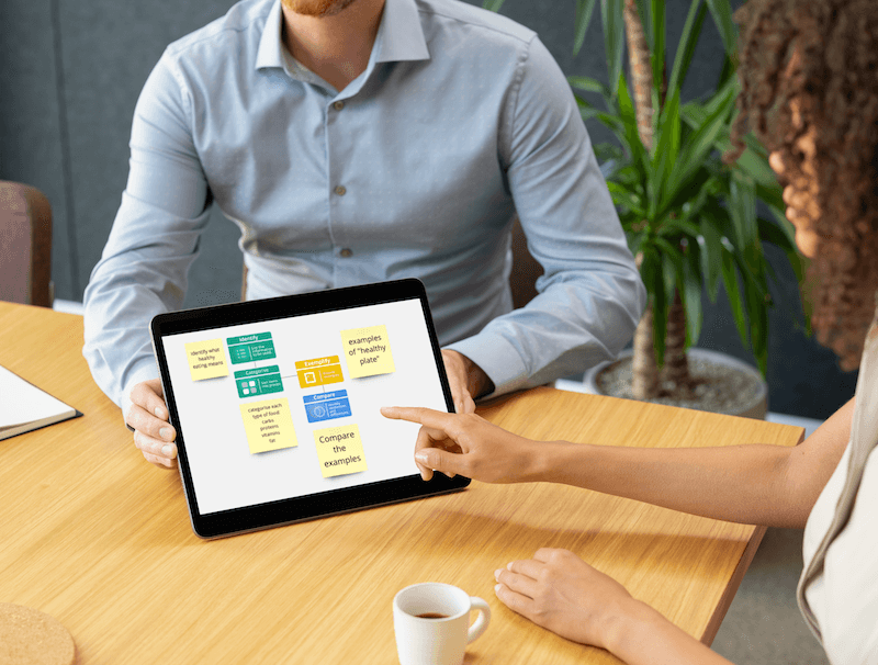 Teacher demonstrating AI lesson planning tool on tablet during collaborative session